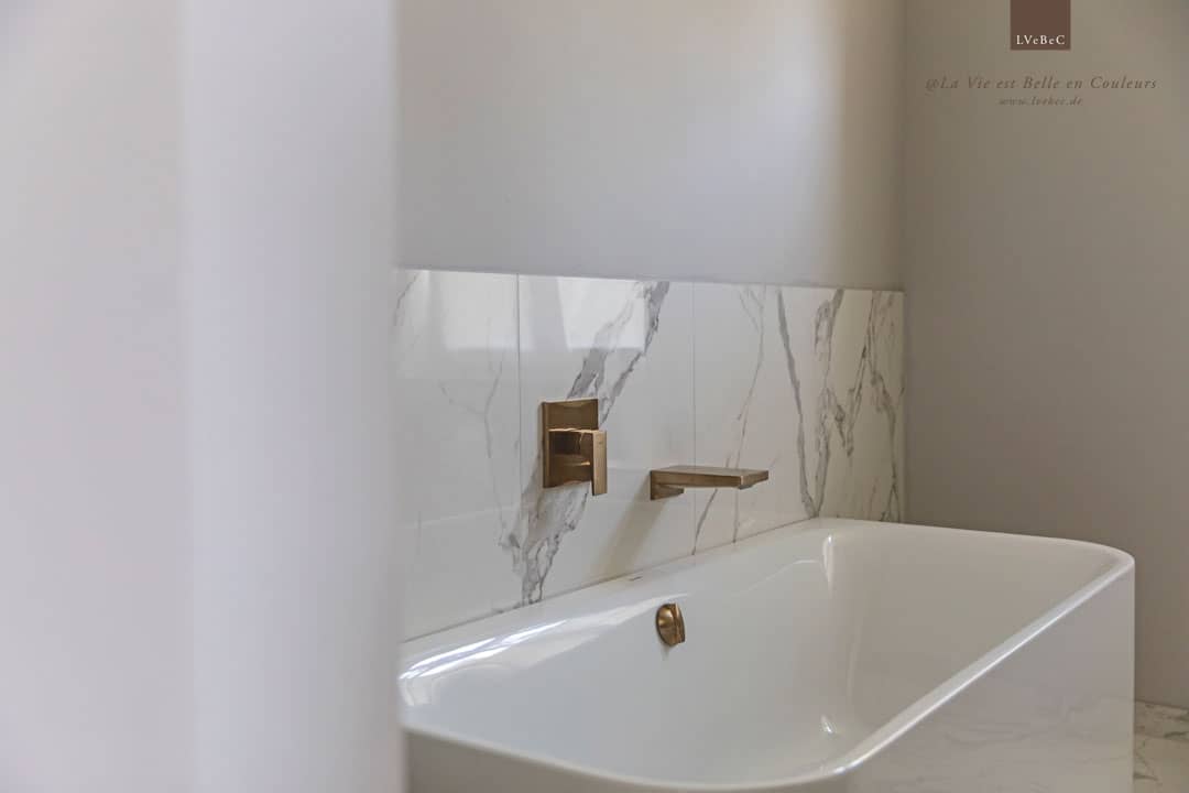 Farbkonzept Badezimmer mit Marmor und hellgrauen Wänden und kupferfarbenen Armaturen