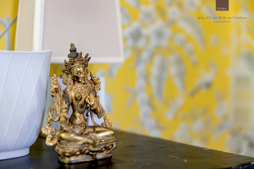 Asiatische Skulptur von gelber, gemusterter Tapete