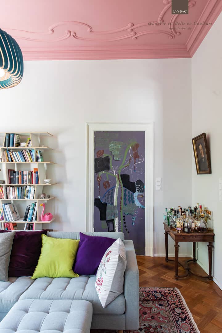 Salon Stuckdecke in Rosarot mit kunstvoller Zimmertuer und Moormann Bücherregal